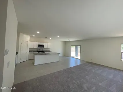 a living room with stainless steel appliances kitchen island furniture and window