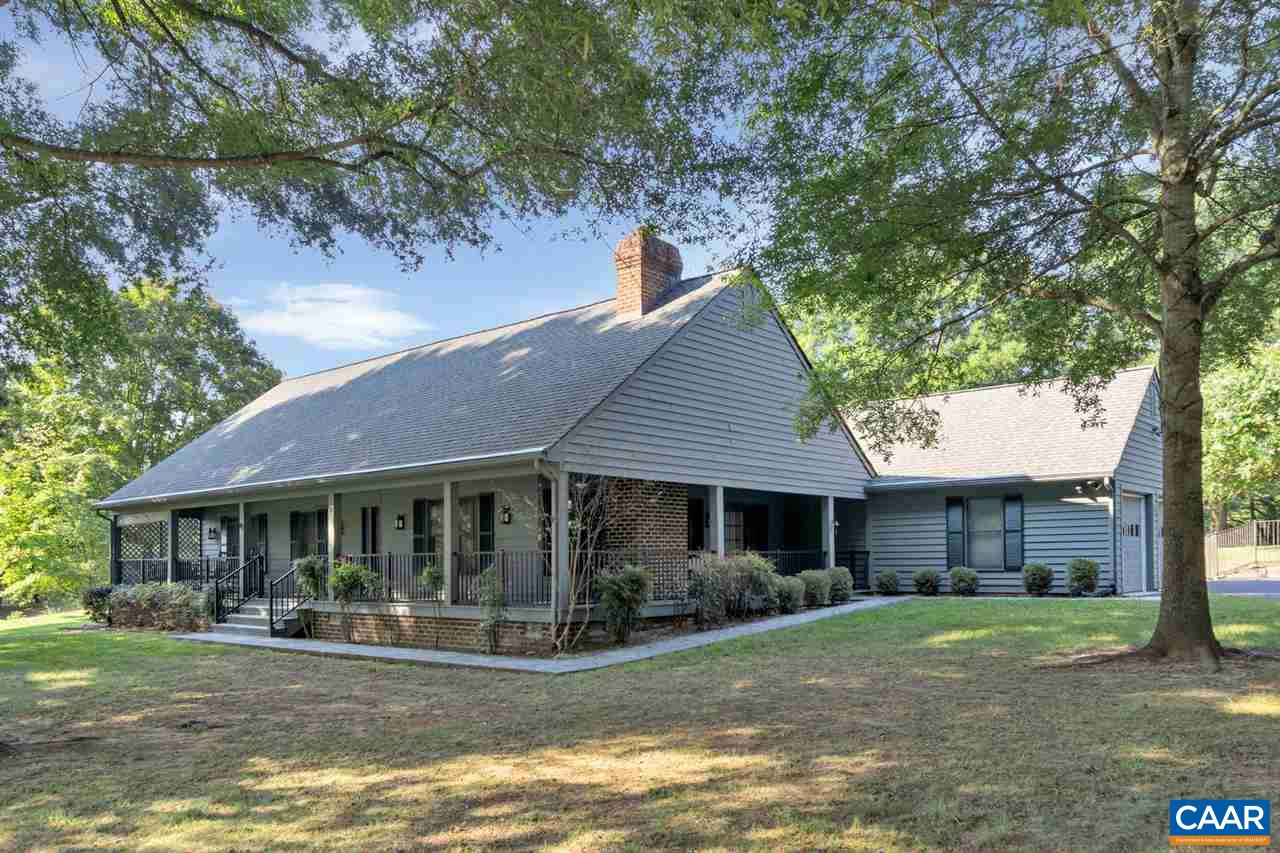 a front view of a house with a yard garden and outdoor seating