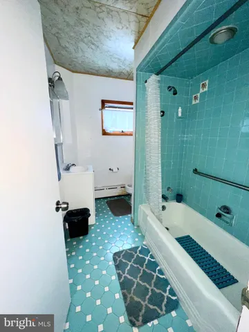 a bathroom with a tub sink and mirror