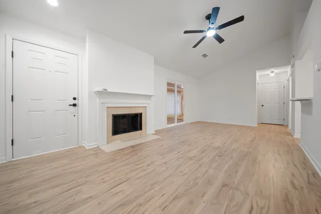 a view of empty room with wooden floor and fireplace