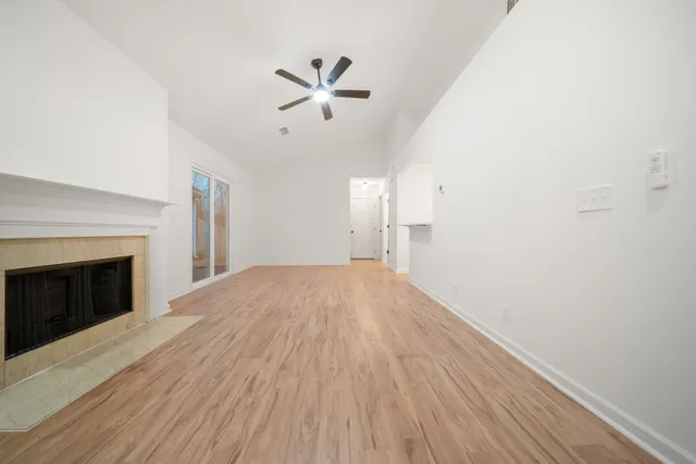 a view of empty room with wooden floor and fireplace