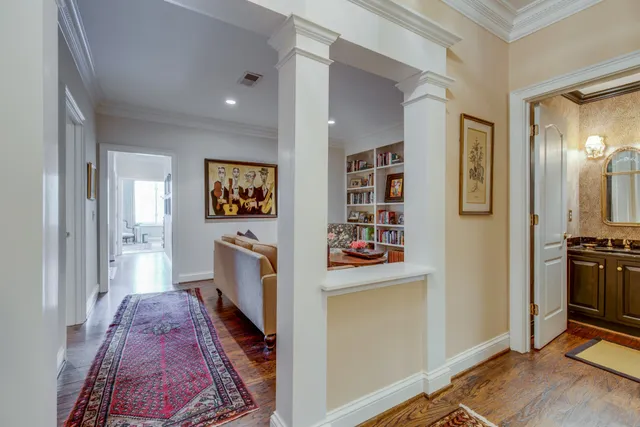 a hallway with dresser and wooden floor