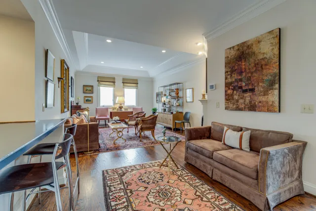 a living room with furniture a rug and a large window