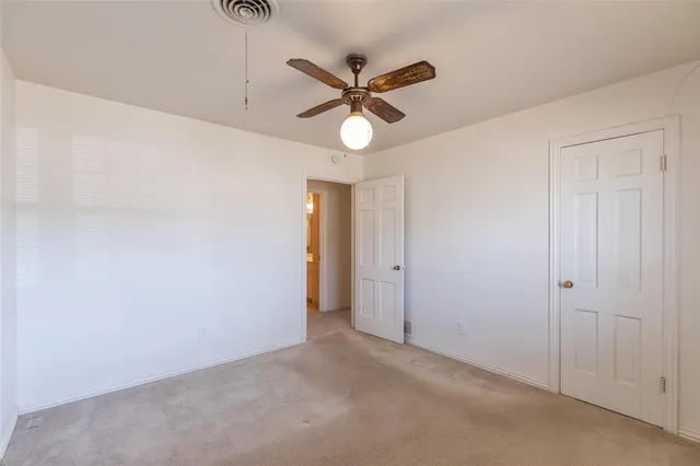 a view of a hallway with a ceiling fan