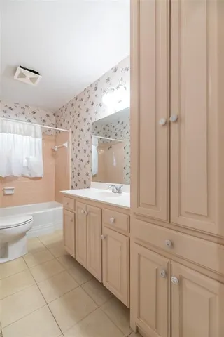 a bathroom with a granite countertop sink a toilet and a bathtub