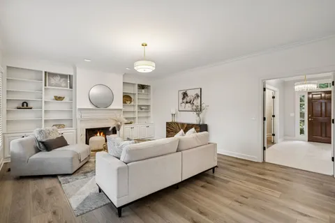 a living room with furniture a fireplace and a large window
