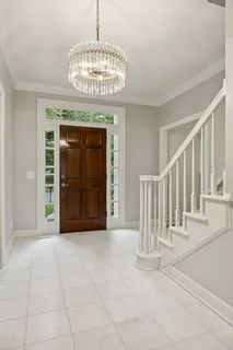 a view of staircase and dining room with wooden floor and a chandelier