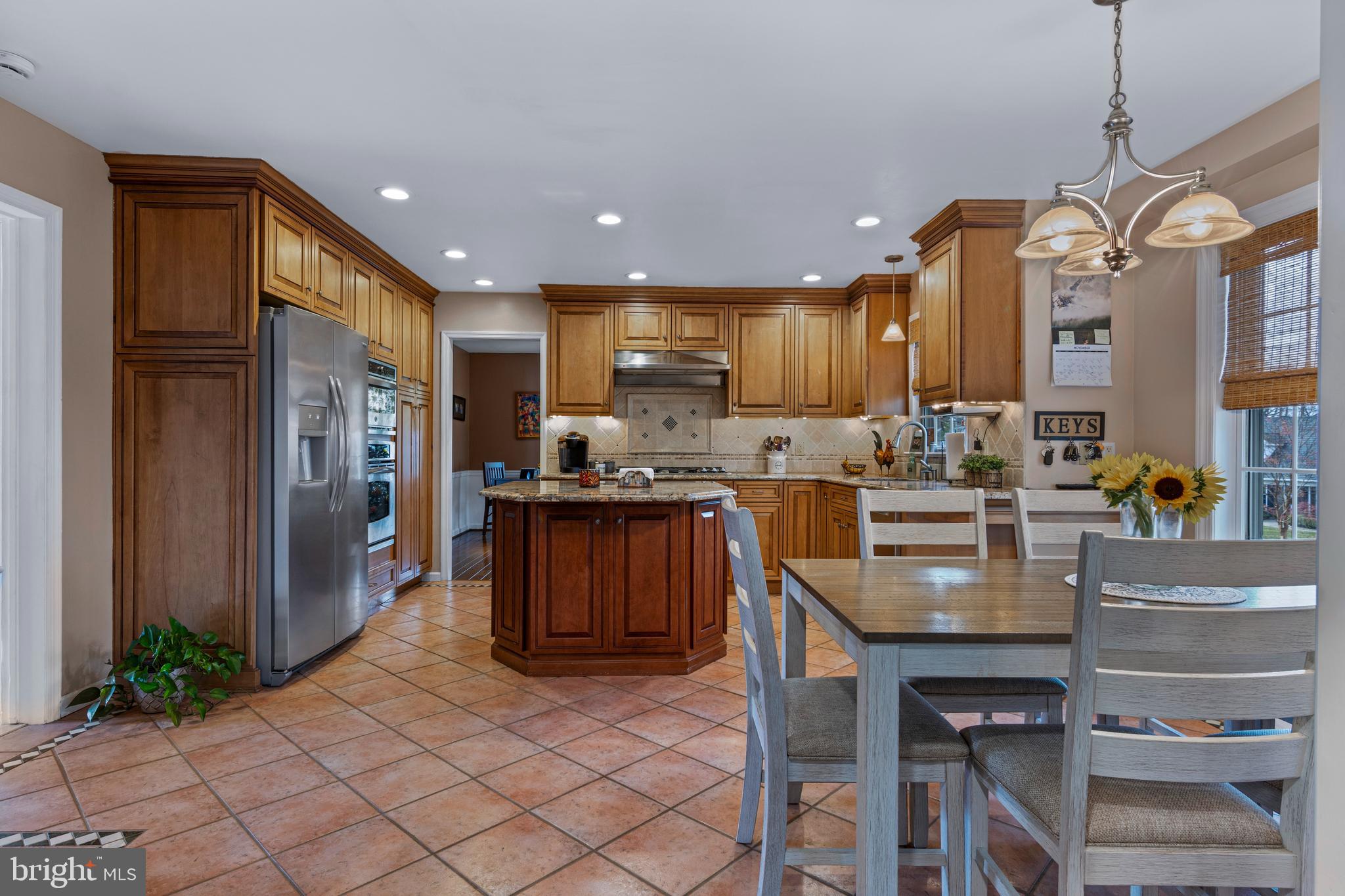 1586 Salomon Lane Chesterbrook, PA 19087 - Photo 14 of 47 a kitchen with stainless steel appliances granite countertop a refrigerator a sink dishwasher a stove and a dining table with wooden cabinet