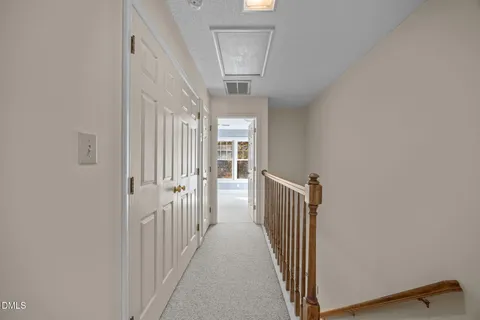 a view of an empty room with window and chandelier fan