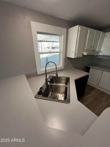 a kitchen with a sink a stove and cabinets
