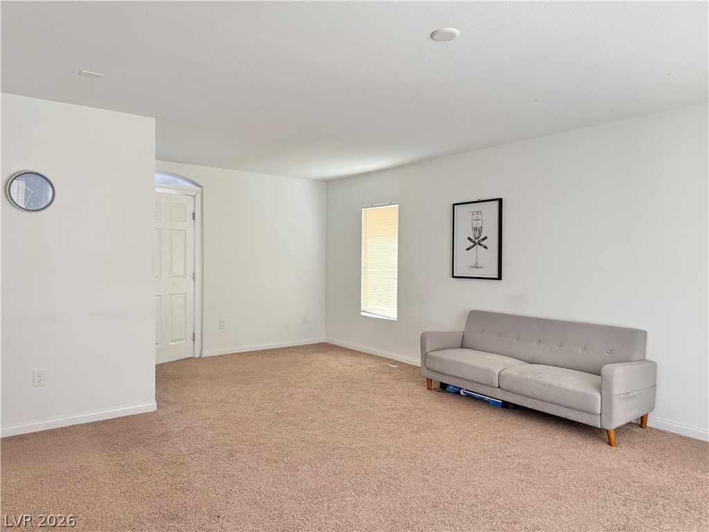 7777 South Westwind Road Las Vegas, NV 89139 - Photo 8 of 46 A spacious, naturally illuminated room featuring warm carpet flooring and a crisp, white aesthetic.