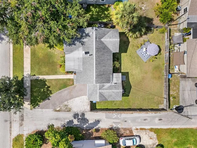 a front view of a house with a yard and potted plants