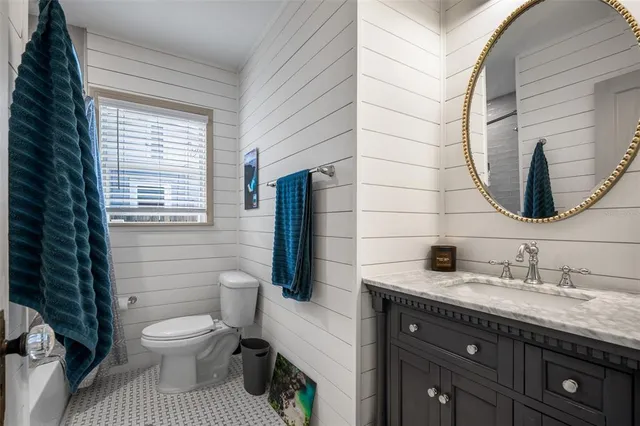 a bathroom with a granite countertop toilet sink and mirror