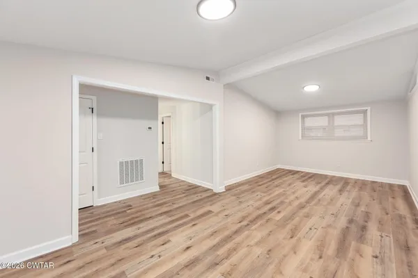 a view of empty room with wooden floor