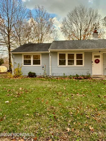 a front view of house with yard and trees