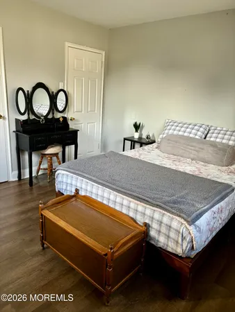 a bed sitting in a bedroom next to a window with a mirror