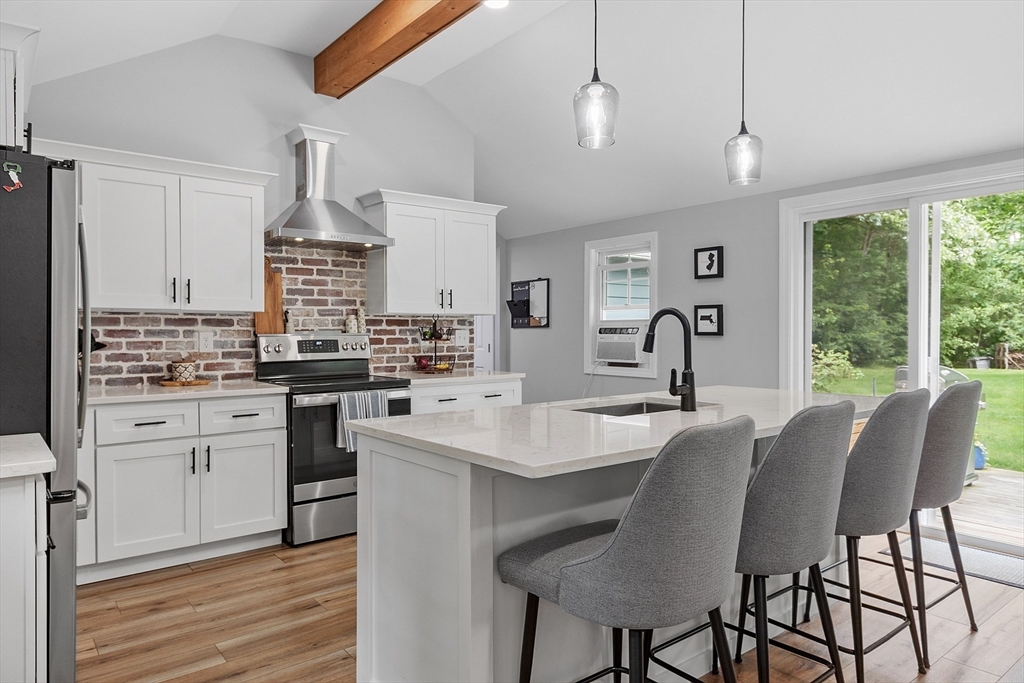 96 Willard Road Ashburnham, MA 01430 - Photo 3 of 30 a kitchen with stainless steel appliances kitchen island granite countertop a table chairs sink and cabinets