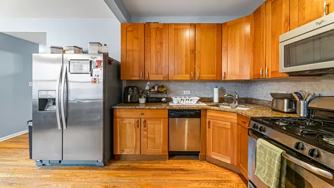 a kitchen with stainless steel appliances granite countertop a refrigerator stove and sink