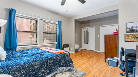 a bedroom with a large bed and a flat tv screen on dresser