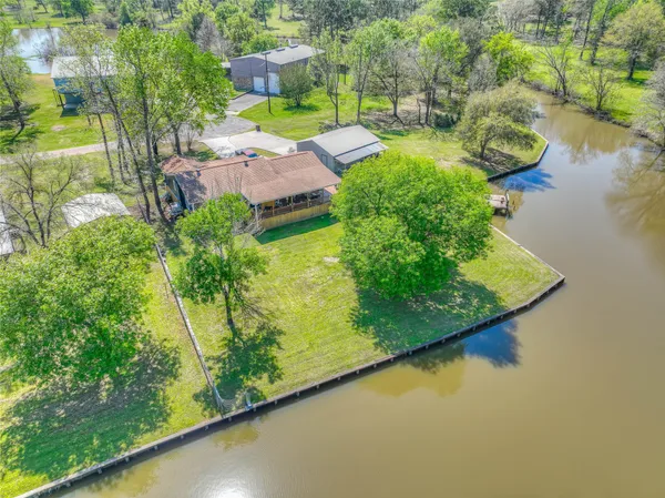 an aerial view of a house with a garden and lake view