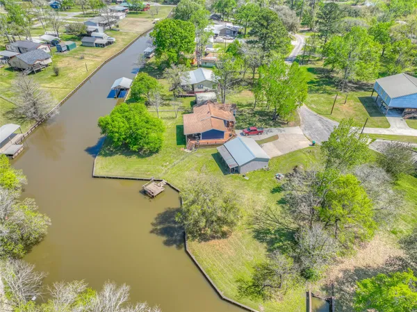 an aerial view of a house with a yard and lake view