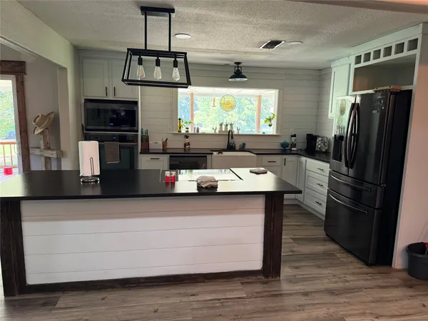 a kitchen with stainless steel appliances a microwave a stove and refrigerator