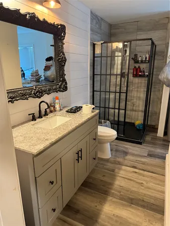 a bathroom with a granite countertop sink toilet and shower