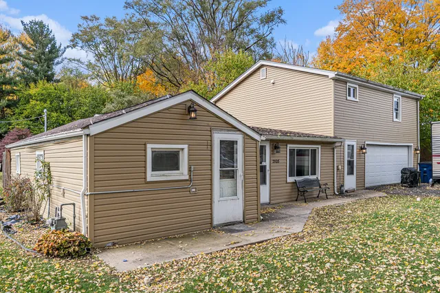 a view of a house with a yard chairs and floor to ceiling window