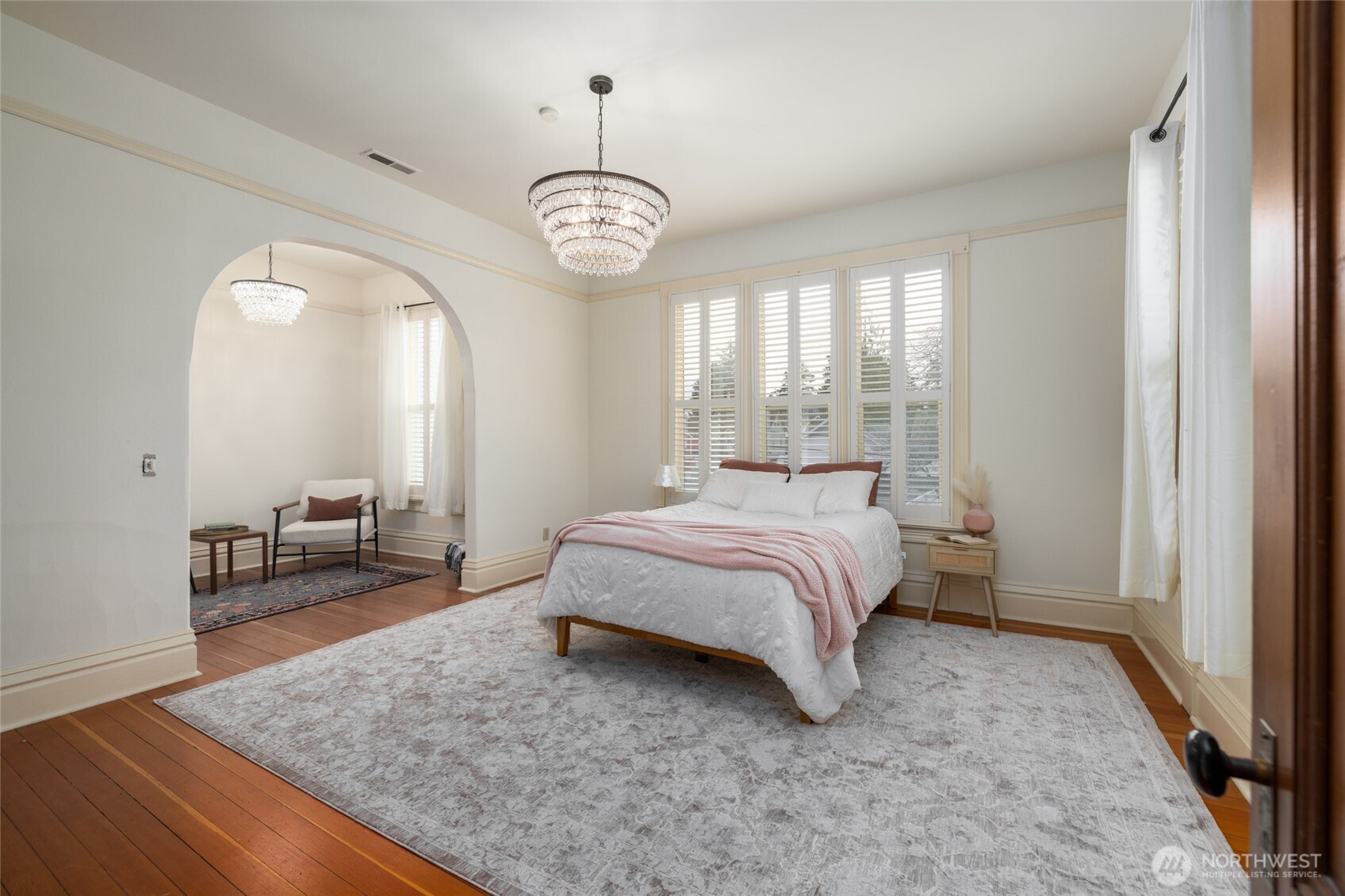 303 Benton Street La Conner, WA 98257 - Photo 14 of 40 a spacious bedroom with a bed and a chandelier