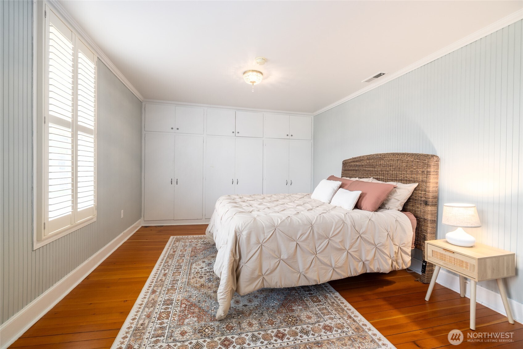 303 Benton Street La Conner, WA 98257 - Photo 16 of 40 a bedroom with a bed and wooden floor