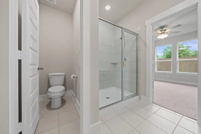 a bathroom with a toilet and a shower
