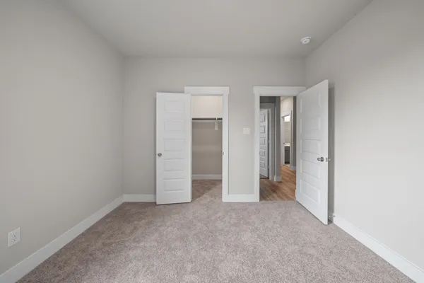 an empty room with closet and a bathroom