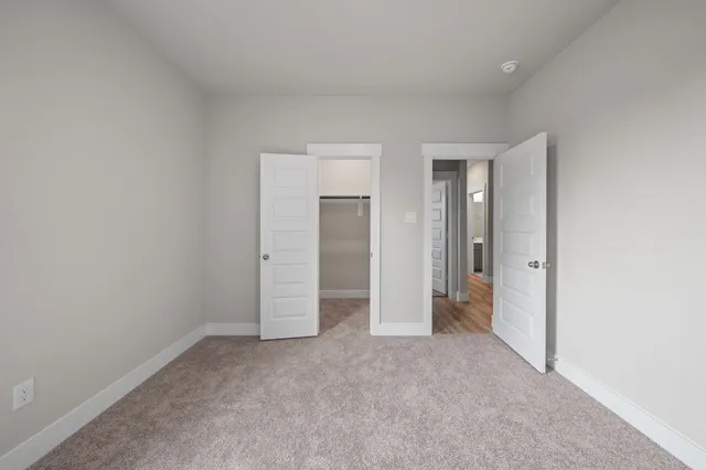 an empty room with closet and a bathroom