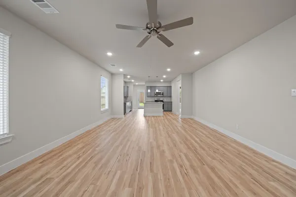 a view of empty room with wooden floor