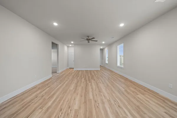 a view of empty room with wooden floor