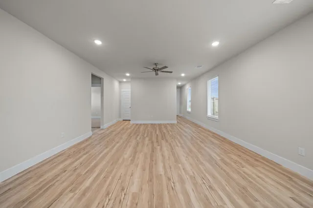 a view of empty room with wooden floor