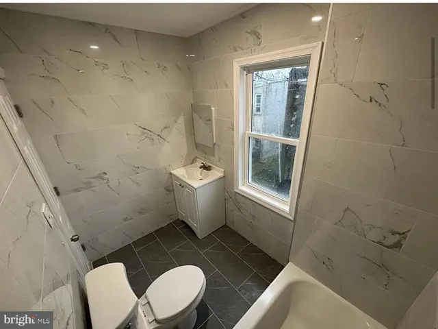 a white toilet sitting next to a bathroom sink