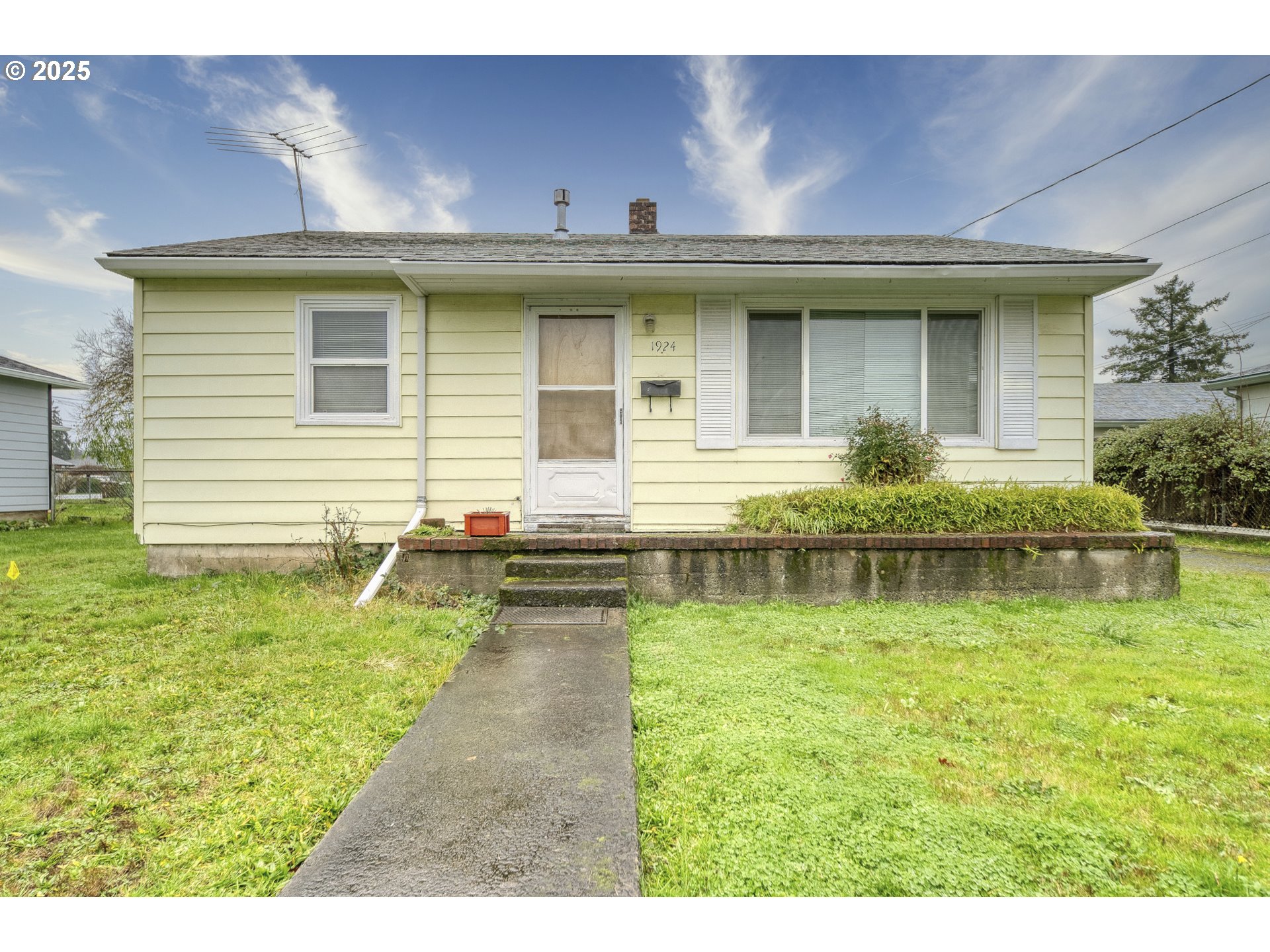 a view of a house with a yard lawn chairs and a fire pit