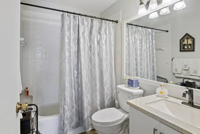 a bathroom with a sink a toilet and shower curtain