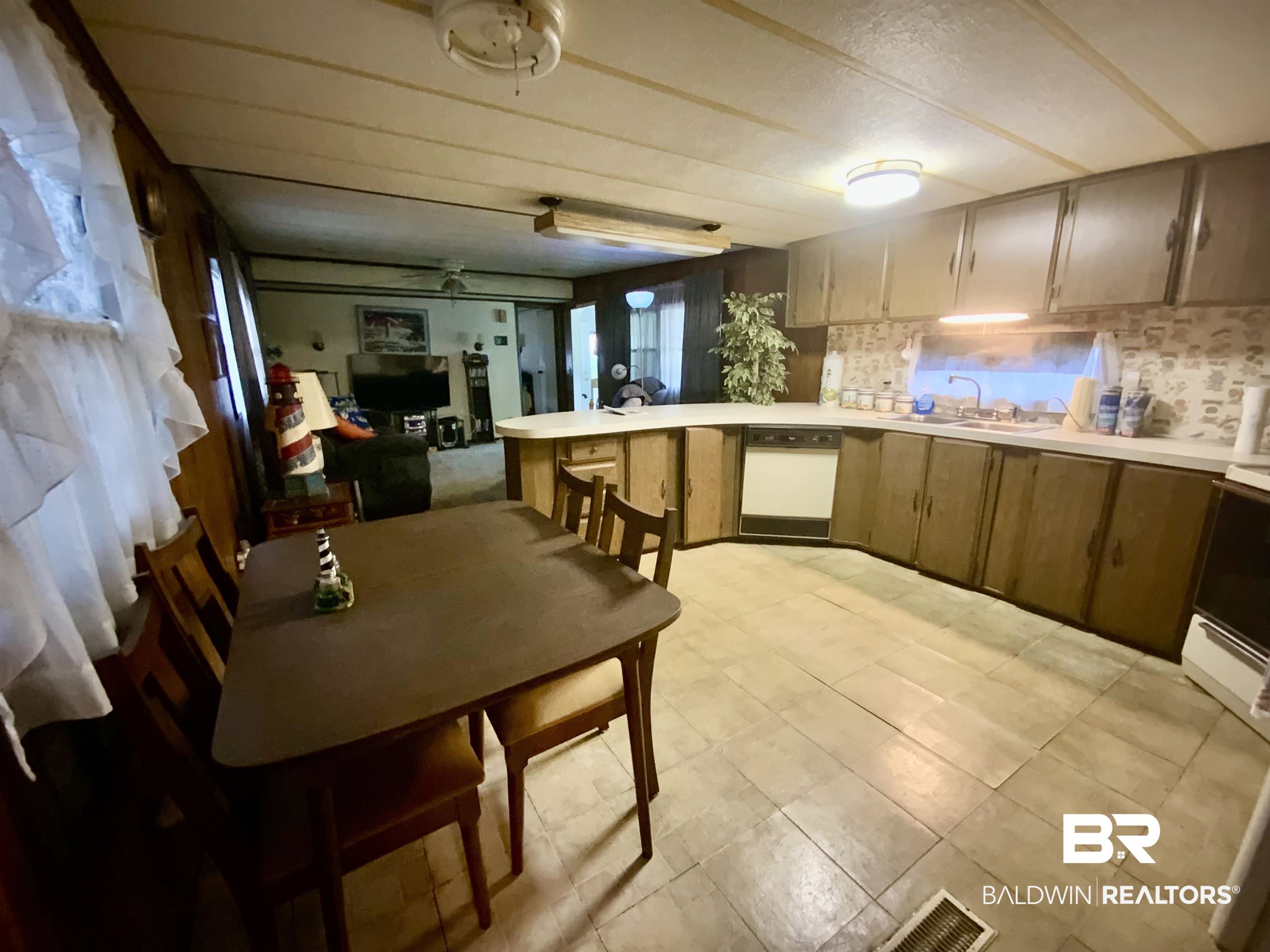 1413 Ridgewood Drive Lillian, AL 36549 - Photo 23 of 23 Kitchen with light countertops, open floor plan, a peninsula, dark brown cabinetry, and range