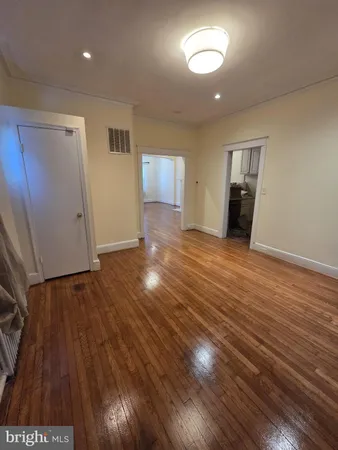 a view of empty room with wooden floor and fireplace