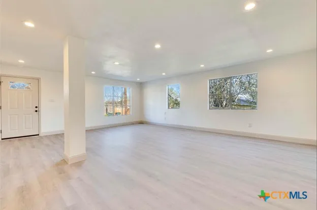 an empty room with windows and closet