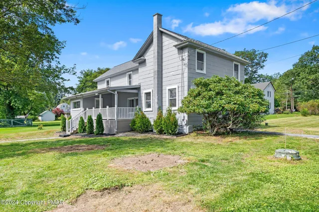 a view of a house with a yard and sitting area