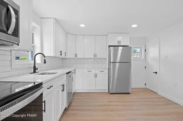 a kitchen with a refrigerator sink and cabinets