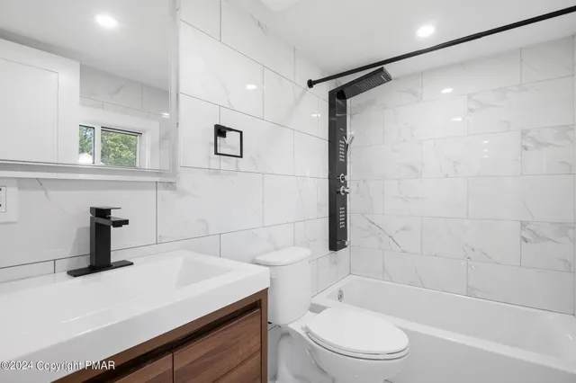 a bathroom with a sink a toilet and shower