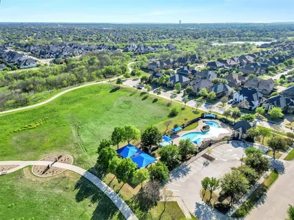 an aerial view of residential houses with outdoor space and trees