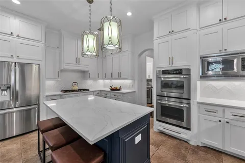 a kitchen with kitchen island a counter appliances a sink and cabinets