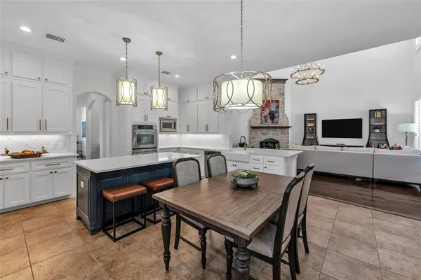 a kitchen with a table chairs sink and cabinets