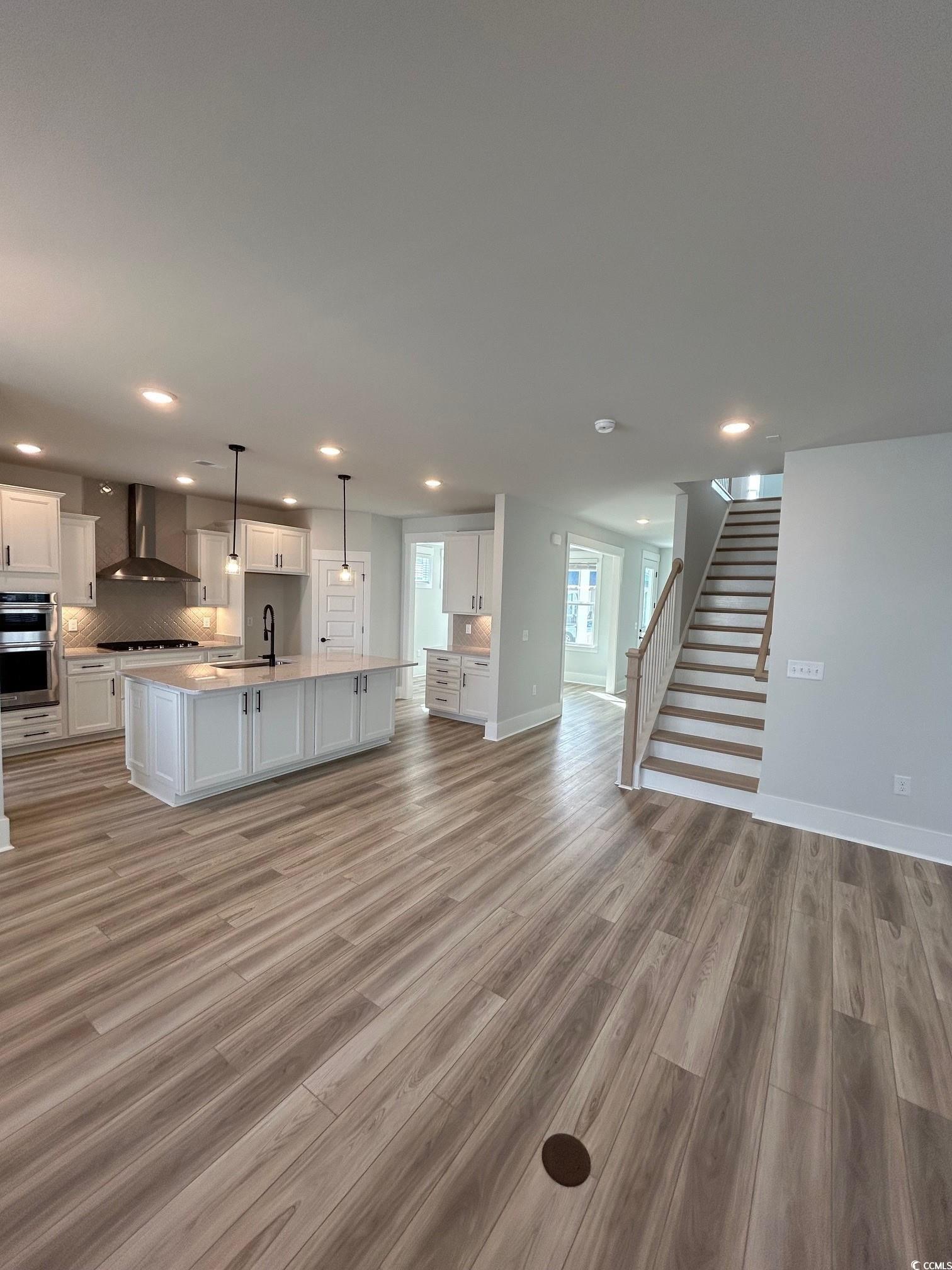 622 Braselton Lane Myrtle Beach, SC 29588 - Photo 6 of 15 Unfurnished living room with light wood finished floors, stairway, a sink, and recessed lighting