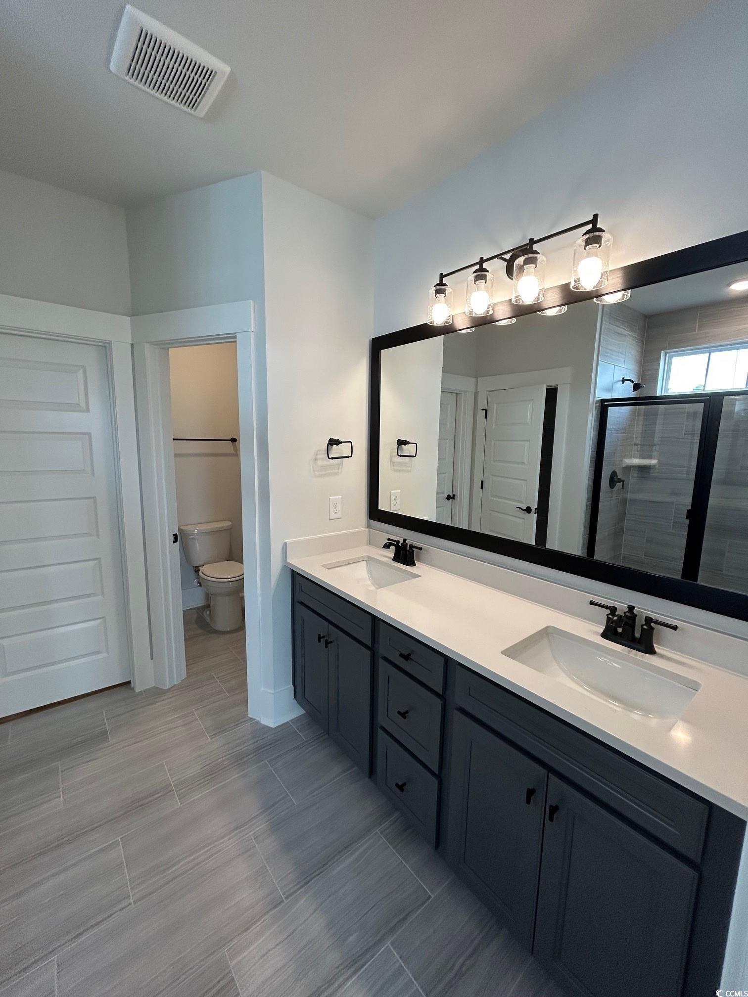 622 Braselton Lane Myrtle Beach, SC 29588 - Photo 8 of 15 Full bath with double vanity, a stall shower, visible vents, and a sink